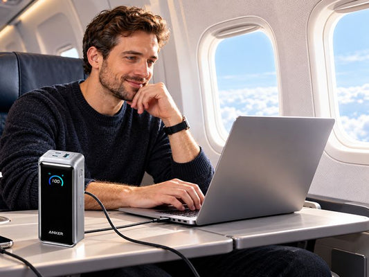 Anker power bank charging a laptop in an airplane cabin